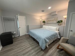 a bedroom with a bed with a blue blanket and a chair at Cozy and Chic Burlington Retreat in Burlington