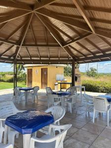 a group of tables and chairs under a large umbrella at GAVOA Beach FLAT in Água Boa