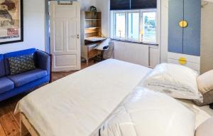a hospital room with a bed and a blue couch at 4 Bedroom Gorgeous Home In Stege in Stege