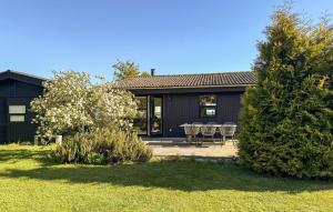 a house with a table and chairs in a yard at 2 Bedroom Cozy Home In Askø in Askø +10 photos