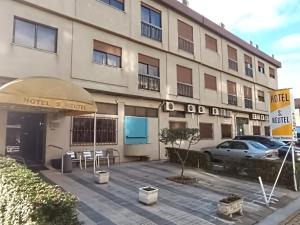 a hotel with a parking lot in front of a building at São Neutel in Chaves