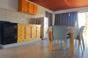 a kitchen with a table and chairs and a dining room at "ATARDECER" Departamento a pocos minutos de termas in Chajarí