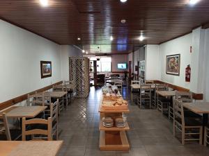 a restaurant with wooden tables and chairs and a cafeteria at São Neutel in Chaves