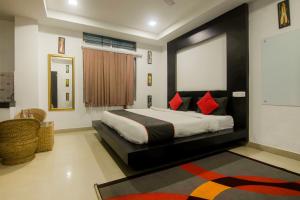 a bedroom with a large bed with red pillows at Hotel OThe Blu Bell in Guwahati
