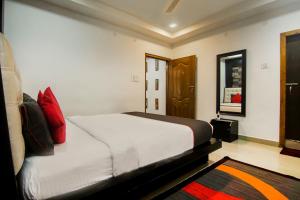 a bedroom with a bed with red pillows on it at Hotel OThe Blu Bell in Guwahati