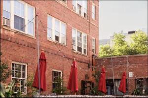 three red umbrellas sitting outside of a brick building at The Wilson in Madison