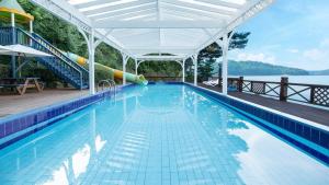a swimming pool with a white canopy and a swimming pool at Taean Supsogui Bada Pension in Panggal-li