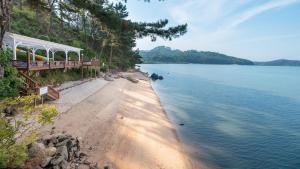 a beach with a pavilion next to a body of water at Taean Supsogui Bada Pension in Panggal-li
