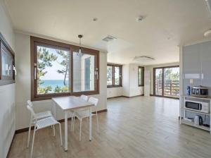 a kitchen with a table and chairs and windows at Onseul Pension Busan in Busan