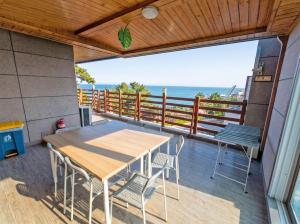 a patio with a table and chairs on a balcony at Onseul Pension Busan in Busan