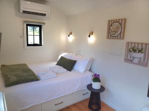 a bedroom with a bed with white sheets and a window at BIG4 Stratford Caravan Park in Stratford