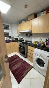 a kitchen with a stove and a washing machine at Sharjah Room in Sharjah