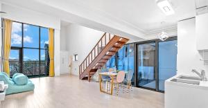 a living room with a staircase and a table and chairs at Gaza Spa Pool Villa Yeosu in Yeosu
