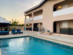 a house with a swimming pool in front of it at Casa Amalia - Jan Thiel Beach in Willemstad