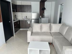 a living room with a couch and a kitchen at Hotel Provenza Suites in Ocaña