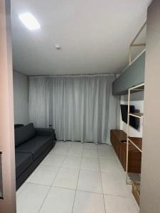 a living room with a couch and a tv at risorte eco carneiros in Tamandaré +6 photos