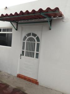 a white house with a white door and a red awning at Gran Tonantzin in San Martín de las Pirámides
