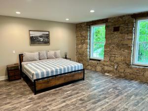 a bedroom with a bed and a stone wall at Grand River Suite in Bellevue