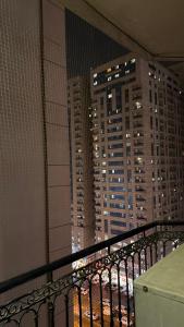 a balcony with a view of a city at night at Sharjah Room in Sharjah