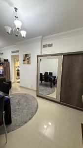 a living room with a mirror and a dining room at Sharjah Room in Sharjah