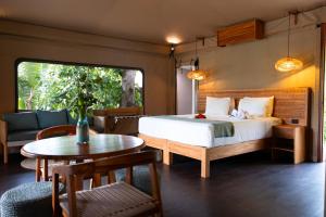 a bedroom with a bed and a table and chairs at Serenity Sands Island Glamping in Bounty Island