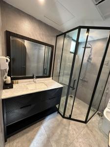 a bathroom with a glass shower and a sink at Villa Florent in Thanh Hóa +11 photos