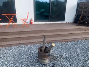 a wooden deck with a wooden stick in a bucket at Nonsan Yeoyurowa Pension in Nonsan