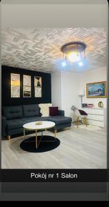 a living room with a couch and a table at Dom Nad Brzegiem Jeziora in Ryn