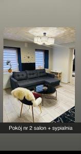 a living room with a couch and a table at Dom Nad Brzegiem Jeziora in Ryn +11 photos