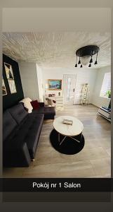 a living room with a couch and a table at Dom Nad Brzegiem Jeziora in Ryn