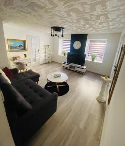 a living room with a couch and a tv at Dom Nad Brzegiem Jeziora in Ryn
