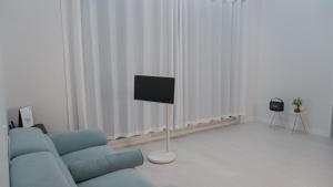 a living room with a blue couch and a flat screen tv at Nonsan Yeoyurowa Pension in Nonsan