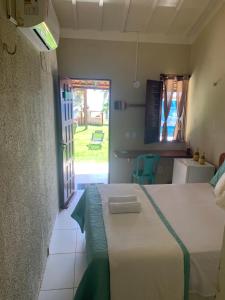 a bedroom with a bed and a door to a yard at Mirante da Lua Residence in Aracati