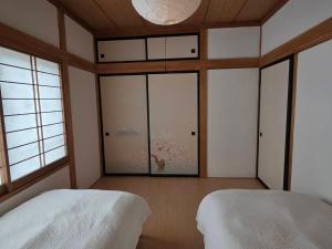 a bedroom with two beds and a large window at GateFuji Fujisan Station in Fujiyoshida