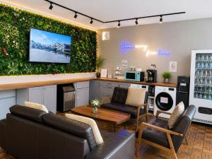 a living room with couches and a tv on a wall at K2 Guesthouse in Singapore