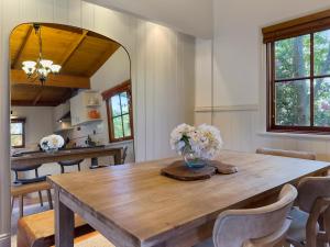 a dining room with a wooden table with flowers on it at Leura Lodge in Leura