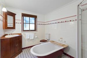 a bathroom with a tub and a toilet and a sink at Leura Lodge in Leura +6 photos