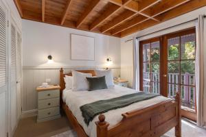 a bedroom with a bed and a large window at Leura Lodge in Leura