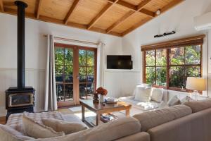 a living room with a couch and a fireplace at Leura Lodge in Leura