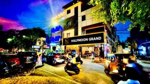 a busy city street with cars and people on motorcycles at Half Moon Grand in Chennai