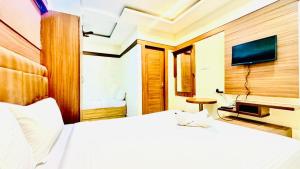 a hotel room with a bed and a tv at Half Moon Grand in Chennai