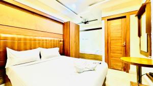 a bedroom with a white bed and a table at Half Moon Grand in Chennai +9 photos