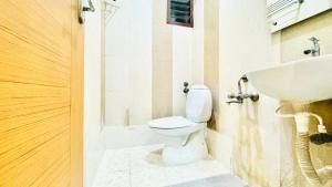a bathroom with a toilet and a sink at Half Moon Grand in Chennai