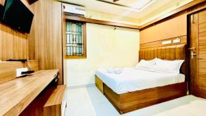 a bedroom with a bed and a television in it at Half Moon Grand in Chennai