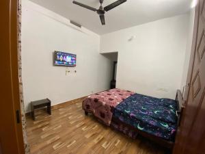 a bedroom with a bed and a tv on the wall at Amber Mount Resorts in Kanthalloor +17 photos