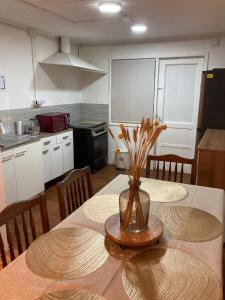 a kitchen with a table with a vase of flowers on it at Casas Rabad in Punta Arenas