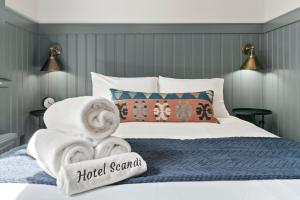 a bed with towels and a hotel scramble sign on it at Hotel Scandi Poulsbo in Poulsbo +78 photos