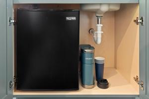 a black refrigerator in a kitchen under a sink at Hotel Scandi Poulsbo in Poulsbo
