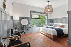 a bedroom with a bed and a window and a chair at Hotel Scandi Poulsbo in Poulsbo