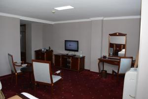 a hotel room with a television and a desk with a mirror at White House Hotel in Ulaanbaatar